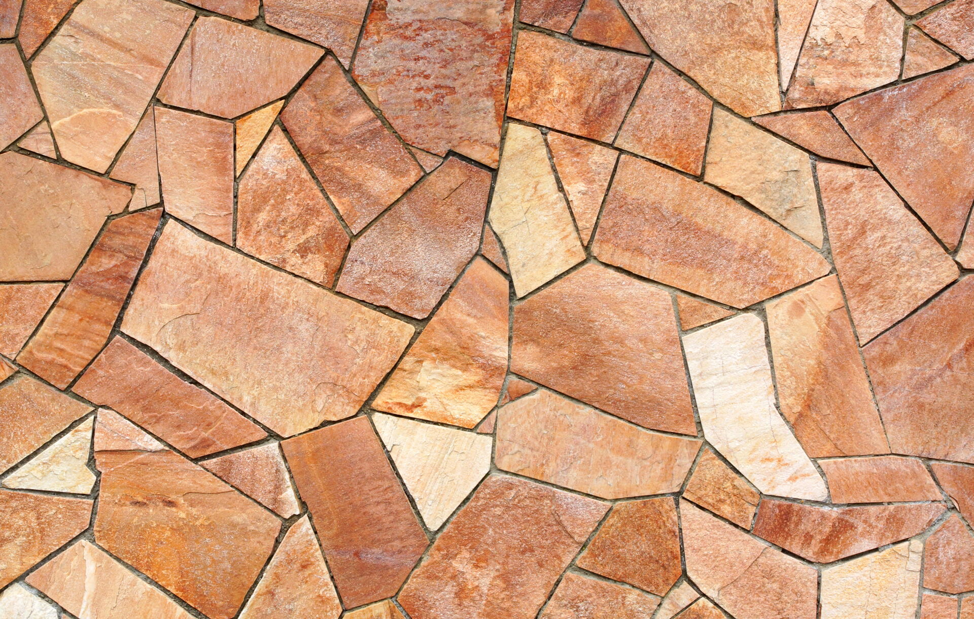 Ein unregelmäßiges Mosaik aus terracottafarbenen Steinen mit dunkleren Fugen. Gestaltungsvorschlag vom Fliesenfachbetrieb Behnisch GmbH in Pulsnitz.