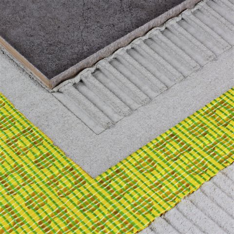 Detailansicht von Dural Durabase CI++ unter einer grauen Fliese auf Estrich mit Kleber. Produkt des Fliesenfachbetriebs Behnisch GmbH in Pulsnitz.